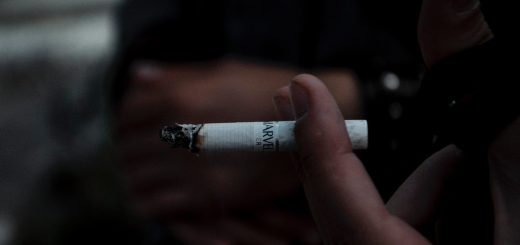person holding white and black cigarette stick